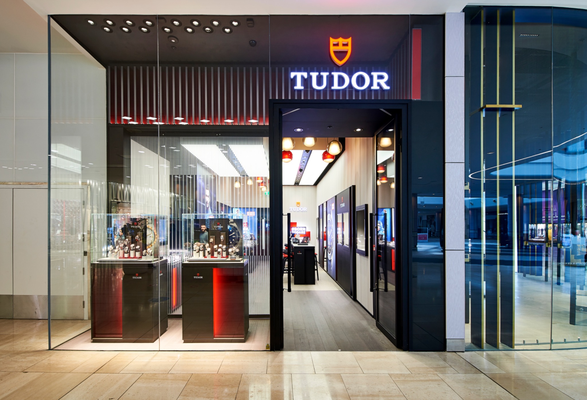 View from the Westfield concourse into the Tudor boutique, framed by its illuminated sign and display windows