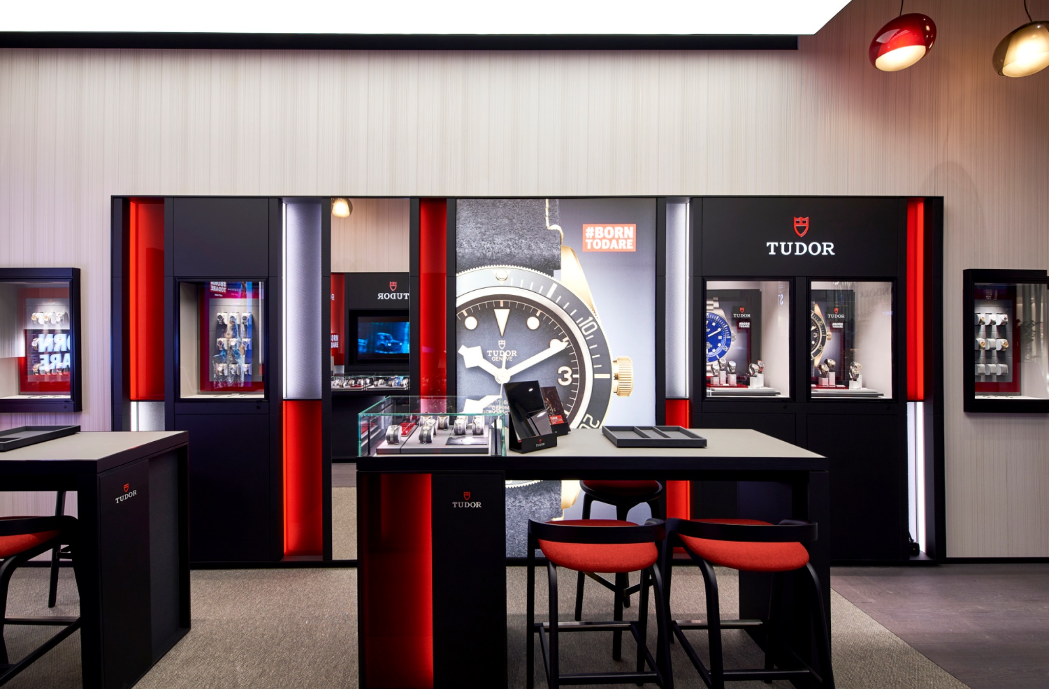 Central watch display and illuminated wall cabinets inside the Tudor boutique