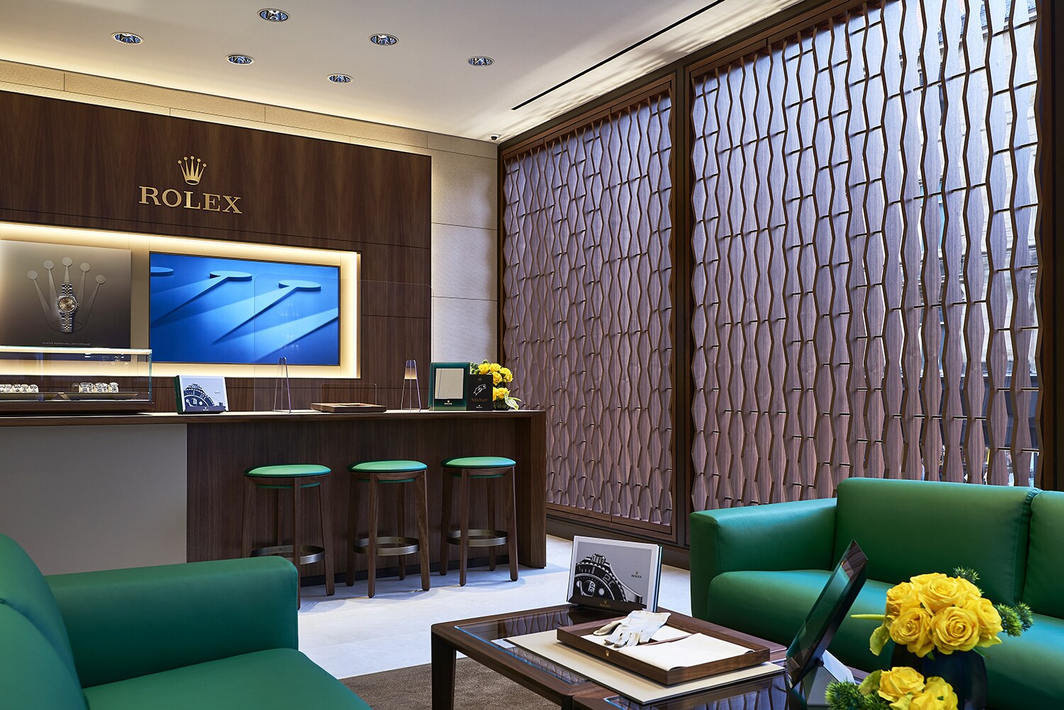 Interior photograph of a completed Rolex retail space, showing timber wall finishes, display counters, seating and decorative screen detailing