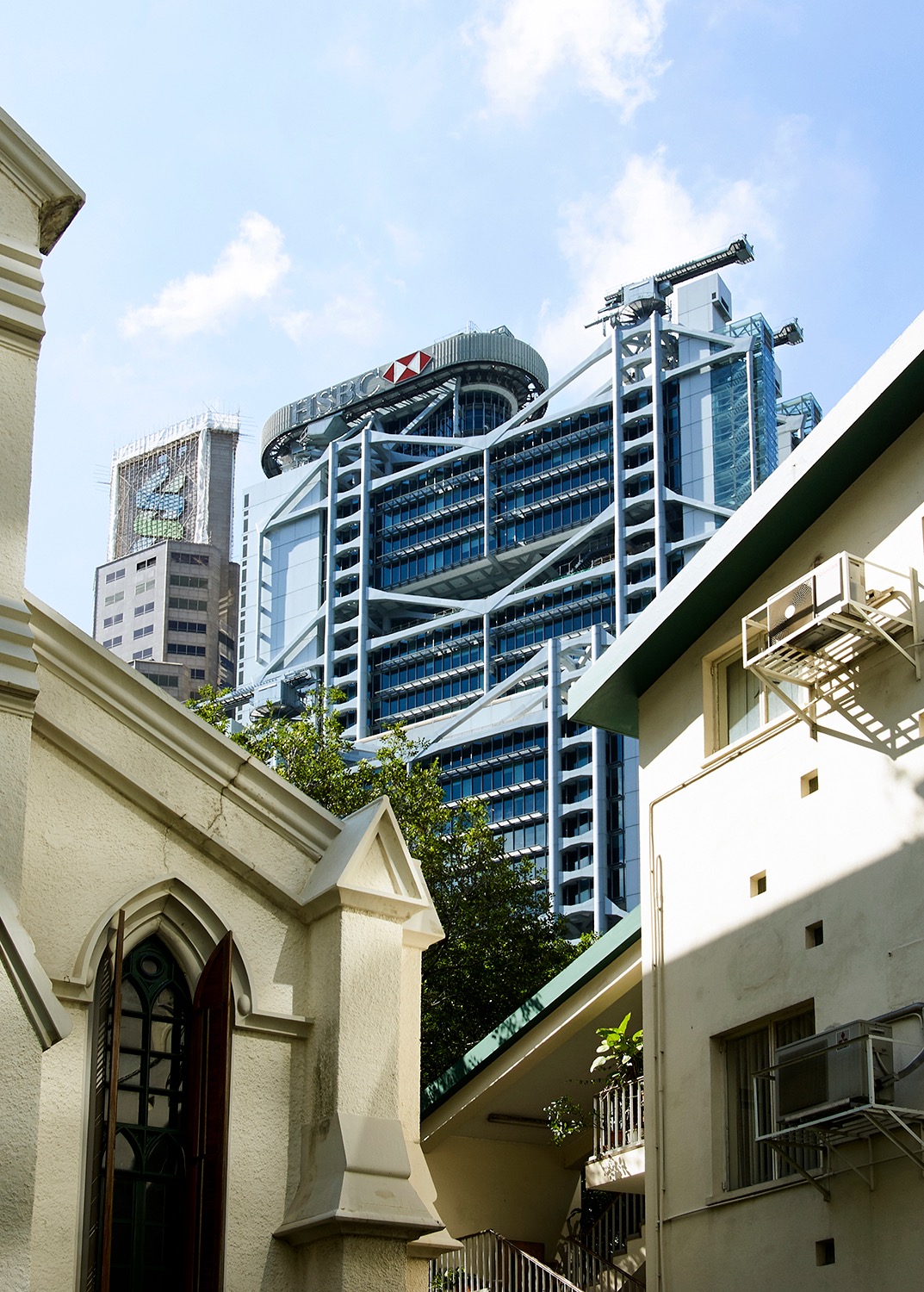 HSBC Main Building rising behind smaller historic buildings in Hong Kong