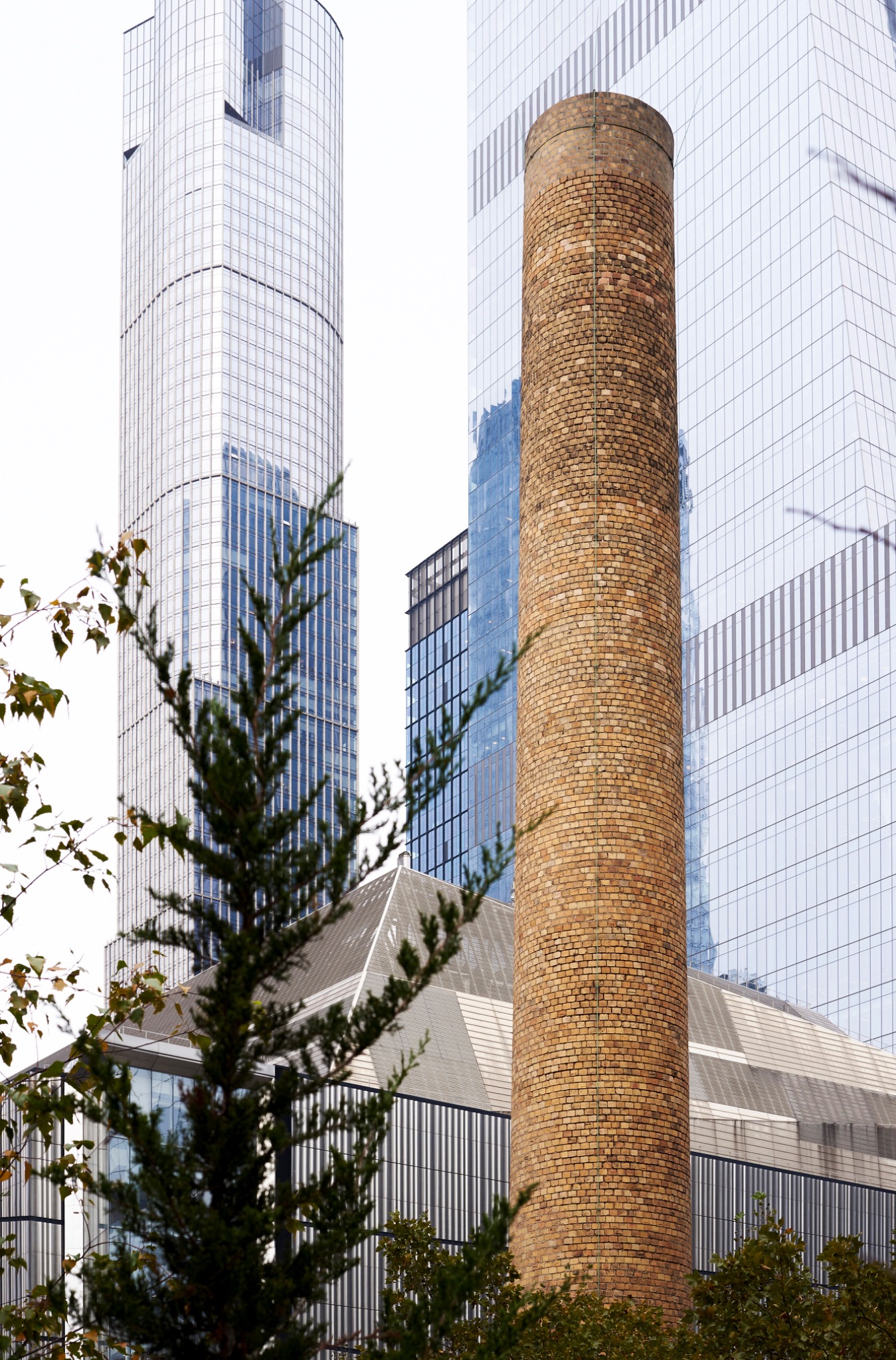 Historic brick chimney aligned with contemporary towers