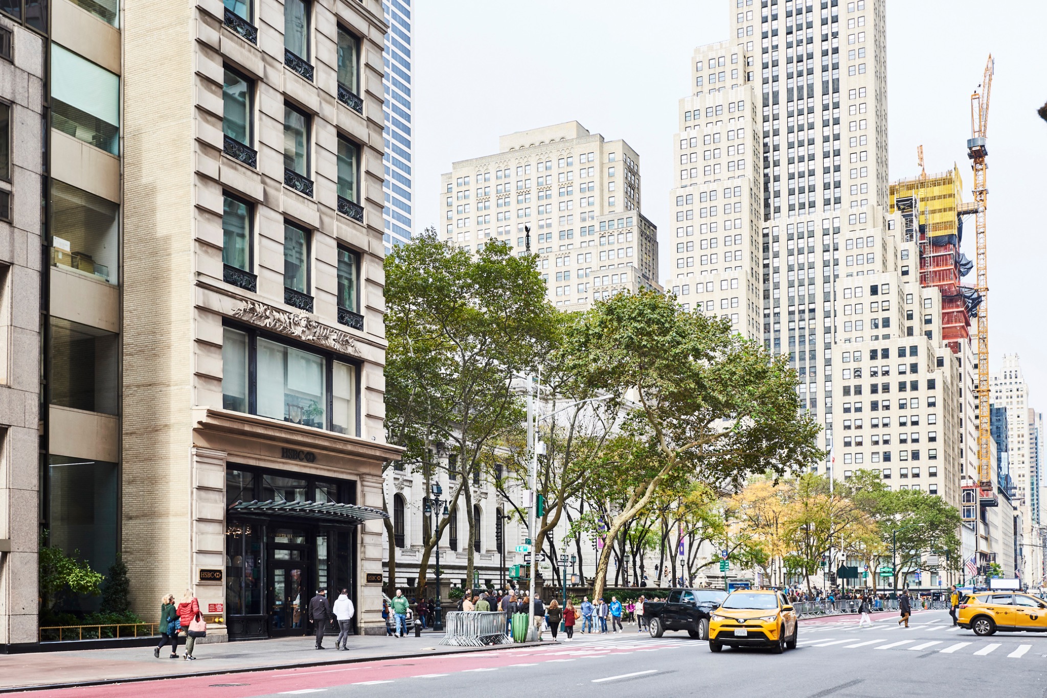 New York avenue framed by buildings, trees, traffic and pedestrians