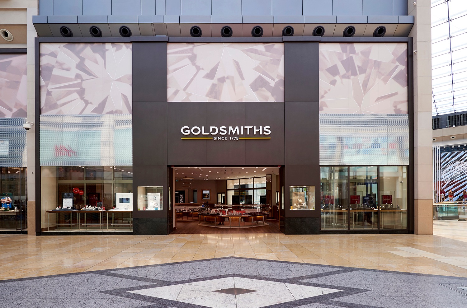 Goldsmiths entrance framed by dark stone and illuminated display panels