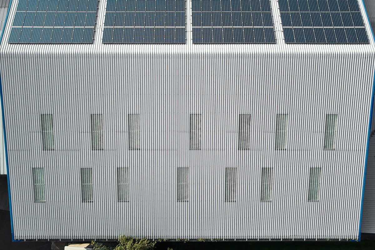 Aerial detail of photovoltaic panels across an industrial roof